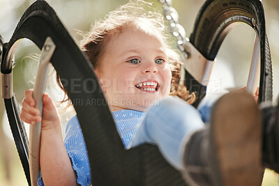 Buy stock photo Girl, kid and playing on swing in park with enjoyment, entertainment and happy for fun activity. Kindergarten, toddler and excited at outdoor playground for break, recreation and child development