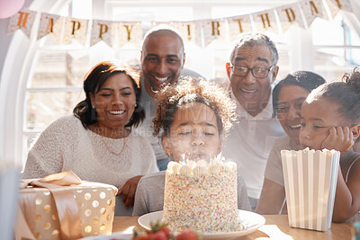 Buy stock photo Girl, birthday cake and blowing candles with family for fun together, happiness and annual milestone in home. Child, event or party for celebration of growth with gift, dessert food and generations