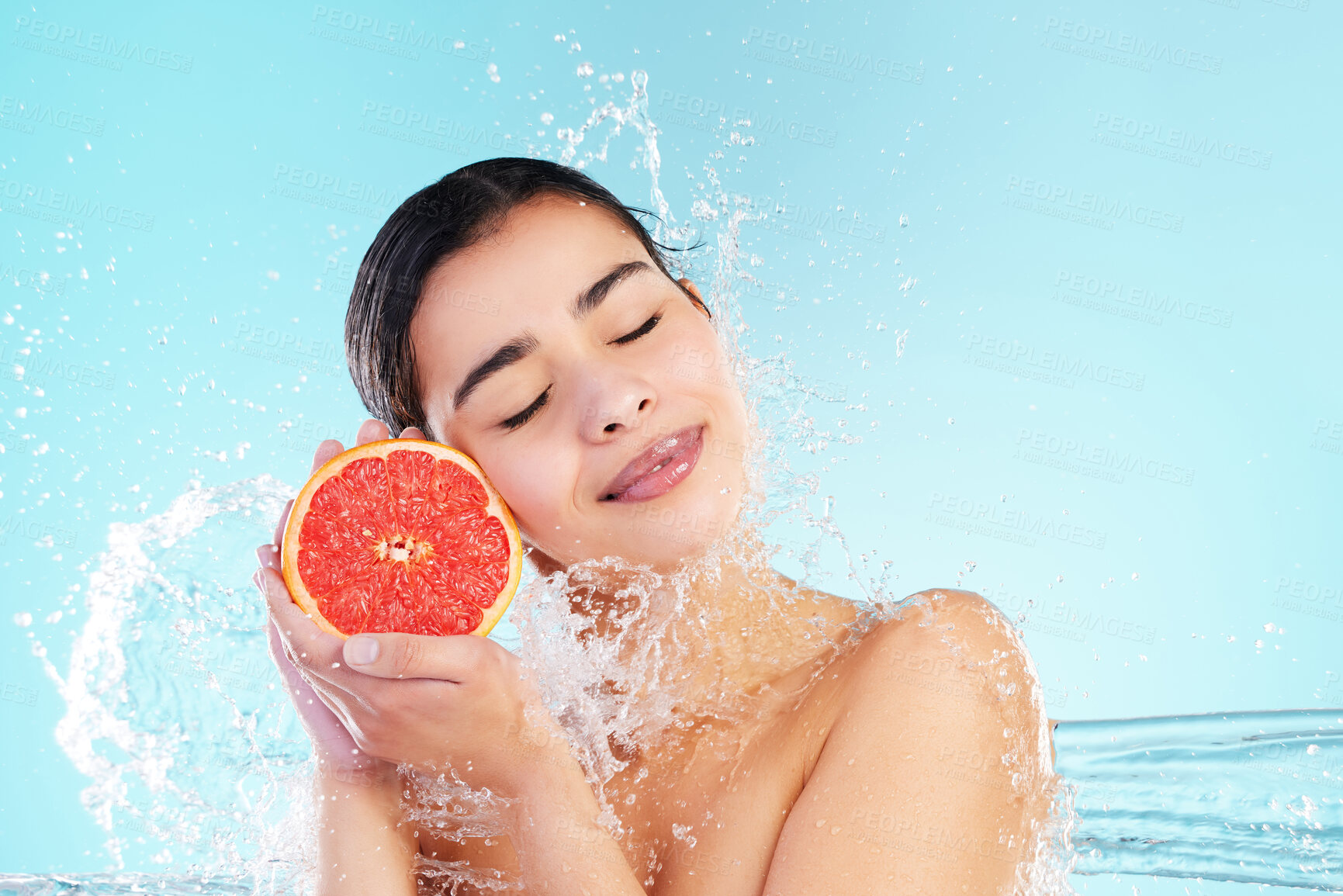 Buy stock photo Woman, water splash and grapefruit in studio, happy and diet with eyes closed by blue background. Girl, model or person with fruits, nutrition and detox for benefits with vegan food with mockup space