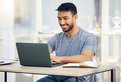 Buy stock photo Shot of a young businessman using a laptop in an office at work