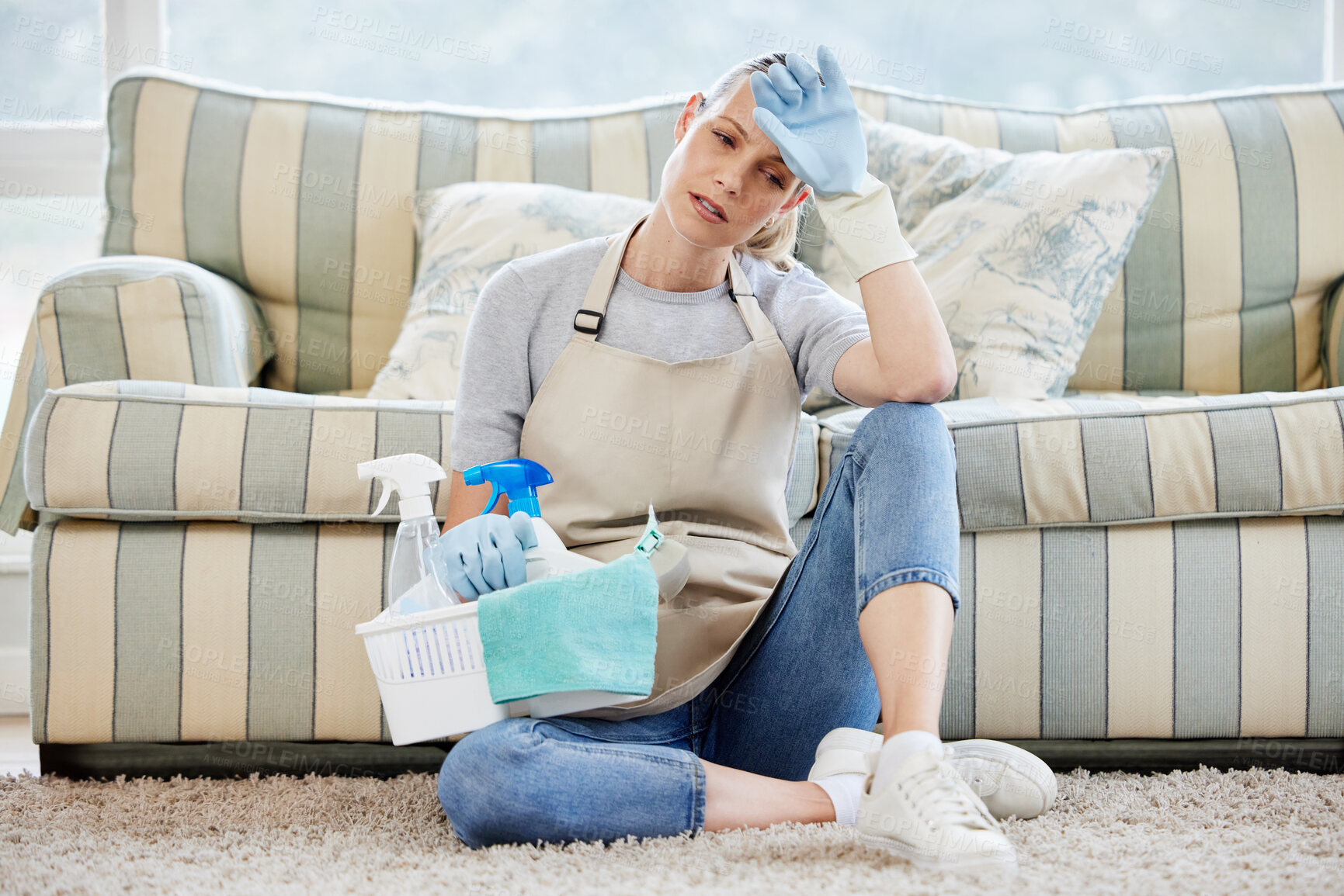 Buy stock photo Frustrated woman, basket and housekeeper with headache or cleaning supplies in fatigue or burnout at home. Tired female person, cleaner or domestic exhausted from tidy house, dirt or bacteria removal