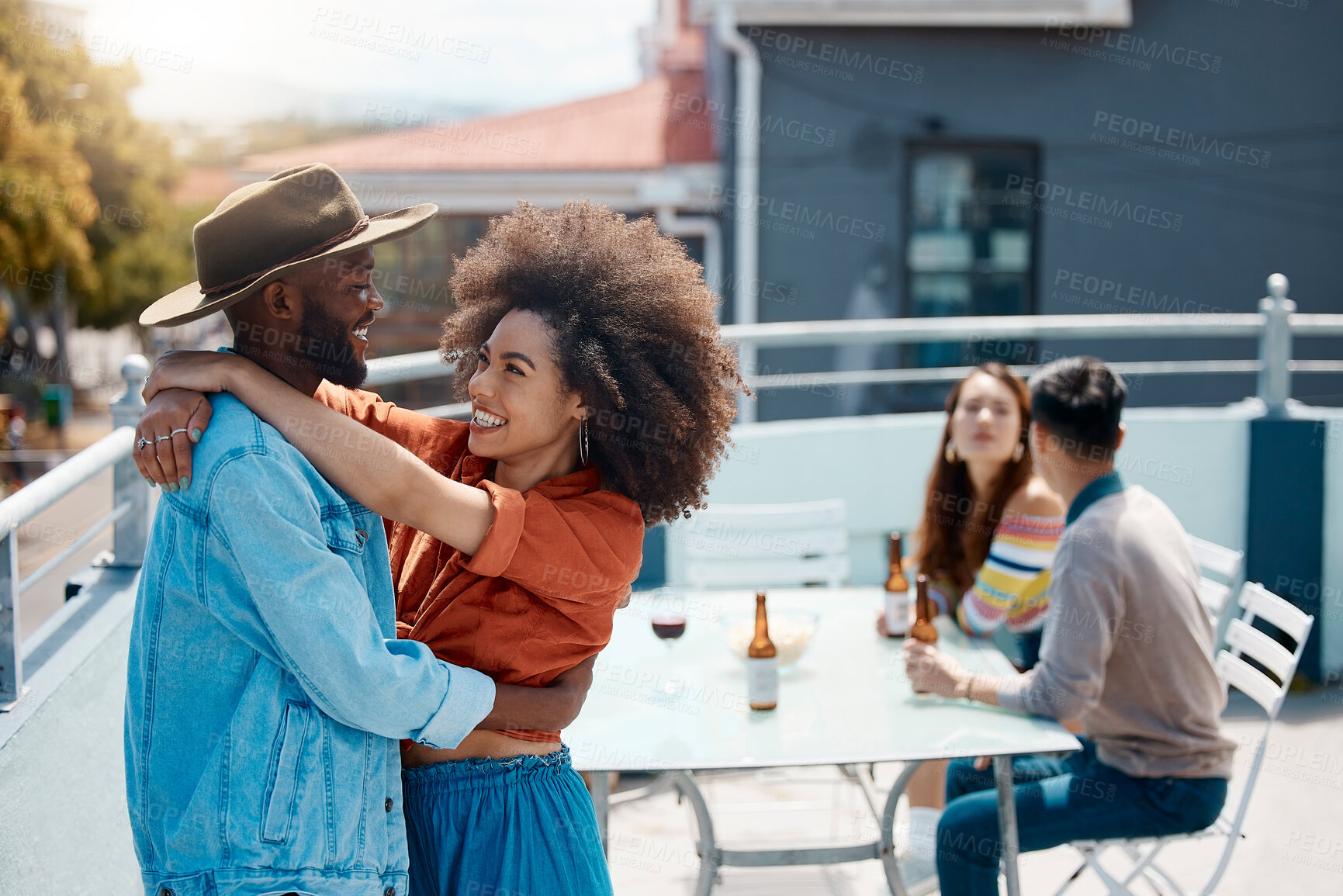 Buy stock photo Smile, hug and couple of friends at rooftop, drinking beer or wine for Octoberfest celebration. Happy man, woman and embrace at party for romance, love or care on group date at home together outdoor