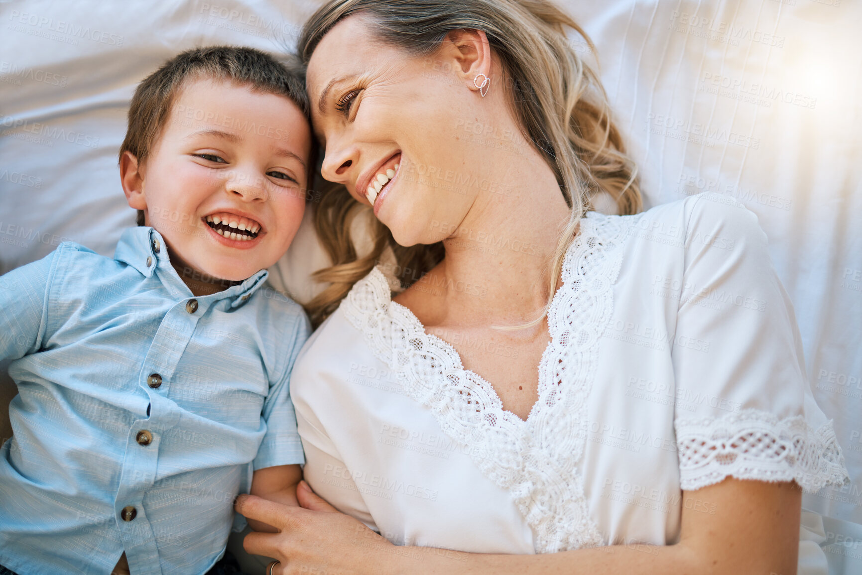 Buy stock photo Laughing, love or smile with mother and son on bed in home from above for bonding, comedy or humor. Family, funny or relax with single parent woman and boy child joking in apartment bedroom together