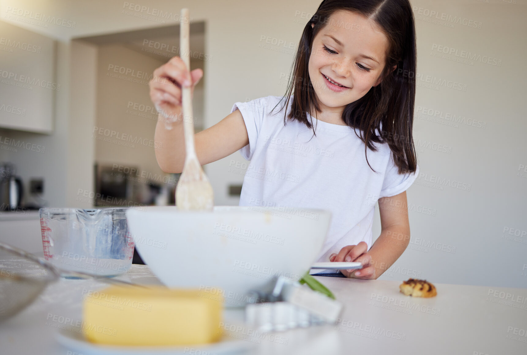Buy stock photo Home, kitchen and girl with bowl for baking, recipe and ingredients for child development with learning. House, counter and kid with dessert, pastry and breakfast preparation with spoon for mixing