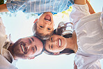 Family of three from below. Portrait of a young couple and their cute son posing outside with the clear blue sky in the background. Happy boy smiling with his mother and father outdoors during summer