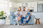 Happy and cheerful caucasian family of four smiling while relaxing together at home. Carefree loving parents bonding with their cute little son and daughter. Siblings sitting with their mom and dad