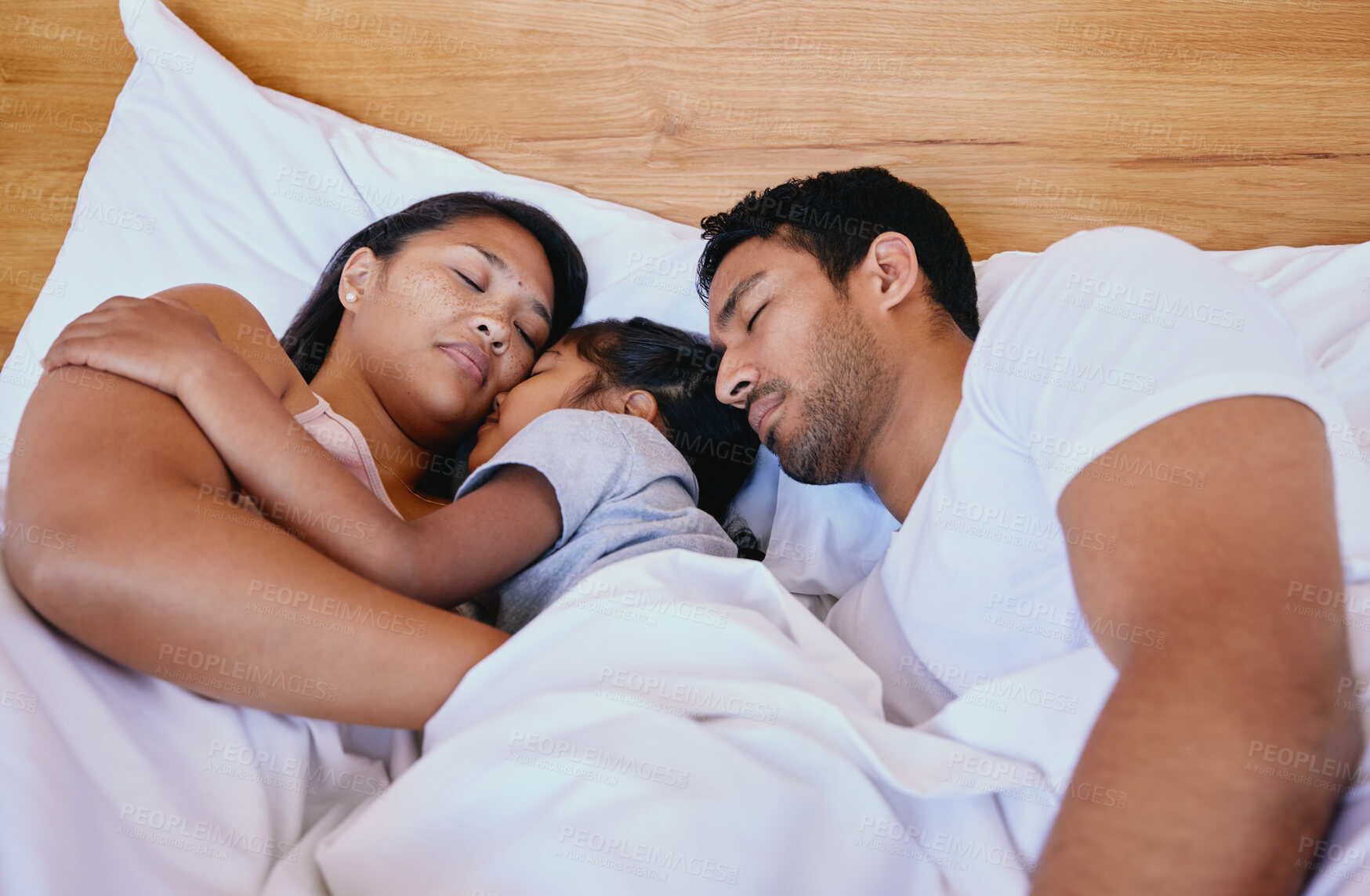 Buy stock photo Relax, sleeping and child with parents in bed with cuddle for protection of nightmare at home. Tired, dreaming and girl kid with mother and father for morning nap with rest in bedroom at family house