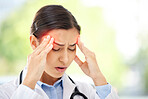 A young mixed race female doctor sitting alone in her clinic and feeling stressed. Hispanic woman suffering a migraine while in a office at work in a hospital