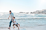 Single dad playing with his son on a beach day. Caucasian single father bonding his son and holding his hand while running with him along the shore. Cute little boy enjoying free time with his parent