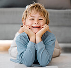 Portrait happy child looking at camera with smiling face. Adorable caucasian kid lying on the floor and relaxing at home. Happy childhood