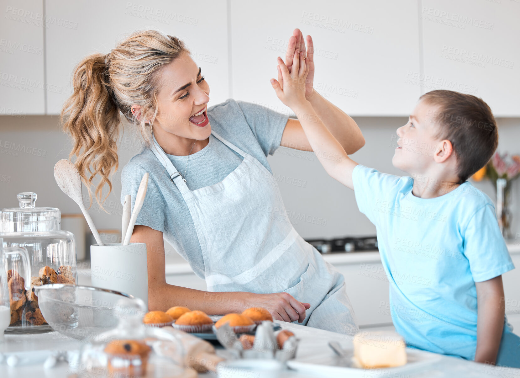 Buy stock photo Mom, boy and high five in kitchen with cooking muffins for hungry family, celebrate or success with healthy food. Mother, son and baking together in home with yes for desert, learning or development