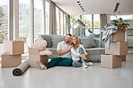 Young happy caucasian couple hugging sitting on the floor of their new house in the lounge. Boyfriend giving his girlfriend a hug after moving into their apartment together