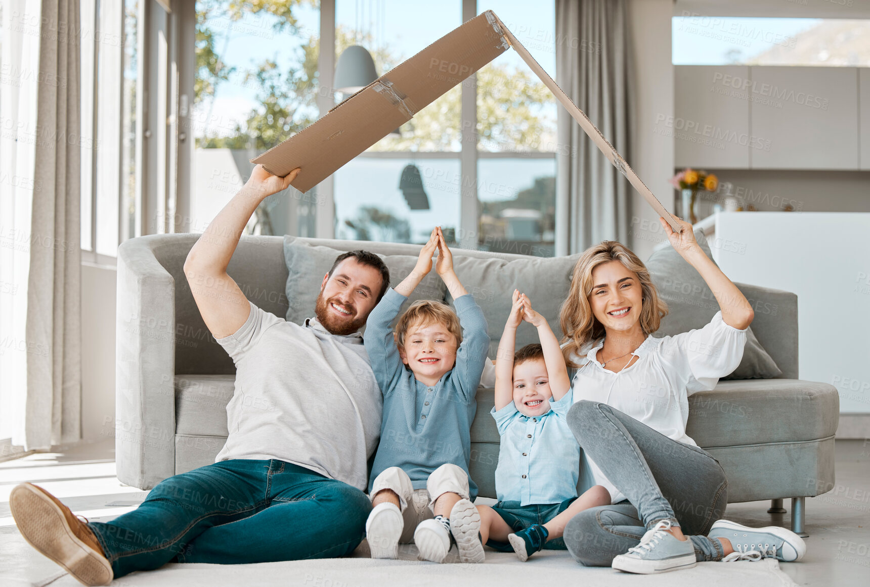 Buy stock photo Together, portrait and family in home for insurance, support and happy for relax or security on floor. Mom, dad or parents with kids and arms for new house with roof, care and love in living room