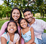 Portrait of happy asian family in the park. Family portrait of husband and wife sitting and enjoying free time with their daughters