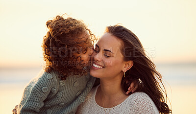 Buy stock photo Mom, girl and kiss at beach for love, care and vacation during summer with wind, smile and hug. Mother, child and relationship outdoor for happiness, childhood and holiday with travel, bonding or fun