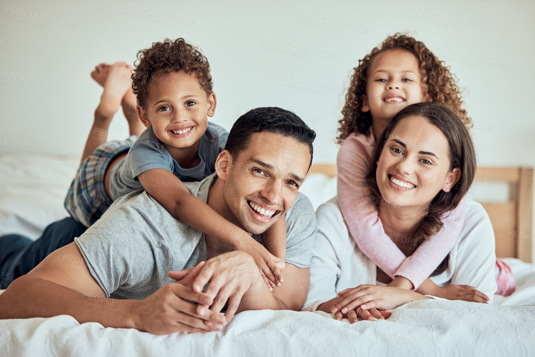 Buy stock photo Happy, family hug and bed portrait in home with children and parents together in the morning. Youth, smile and bonding with love, care and support from mom and dad in bedroom with kids and embrace