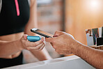 Closeup of unknown man paying for gym membership on cellphone. Mixed race trainer renewing health club subscription on technology. Caucasian coach using card machine to scan payment in fitness centre