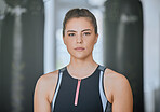 Portrait of one serious woman alone in gym. Beautiful ambitious focused caucasian trainer standing after workout in health club. Young confident coach in fitness centre for routine training exercise