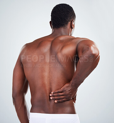 Buy stock photo Black man, back and injury with pain for sore spine, ache or muscle tension in studio on a white background. Muscular African, male person or model with spinal problem, accident or joint inflammation