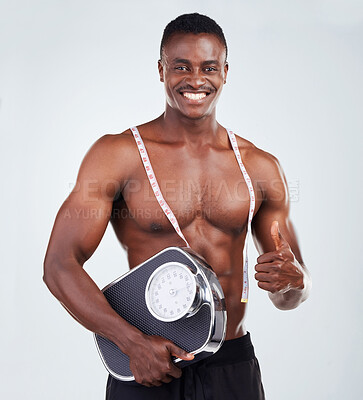 Buy stock photo Measuring tape, scale and portrait of man in studio for bulking progress with body building. Thumbs up, fitness and African male person with weight or bmi tracking tools for gym by white background.