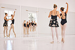 Young woman dance instructor teaching a ballet class to a group of a children in her studio. Ballerina teacher working with girl students, preparing for their recital, performance or upcoming show