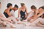 Young woman dance instructor teaching a ballet class to a group of a children in her studio. Ballerina teacher working with girl students, preparing for their recital, performance or upcoming show