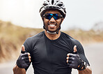 One young man showing thumbs up while cycling outside. Happy male wearing helmet and glasses winning first in competition race. Pleased with his time results and enjoying a break from cardio training