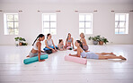 Happy friends relaxing before yoga class together. Young women bonding in pilates class. Happy friends talking before yoga class. Women being social in a pilates studio together