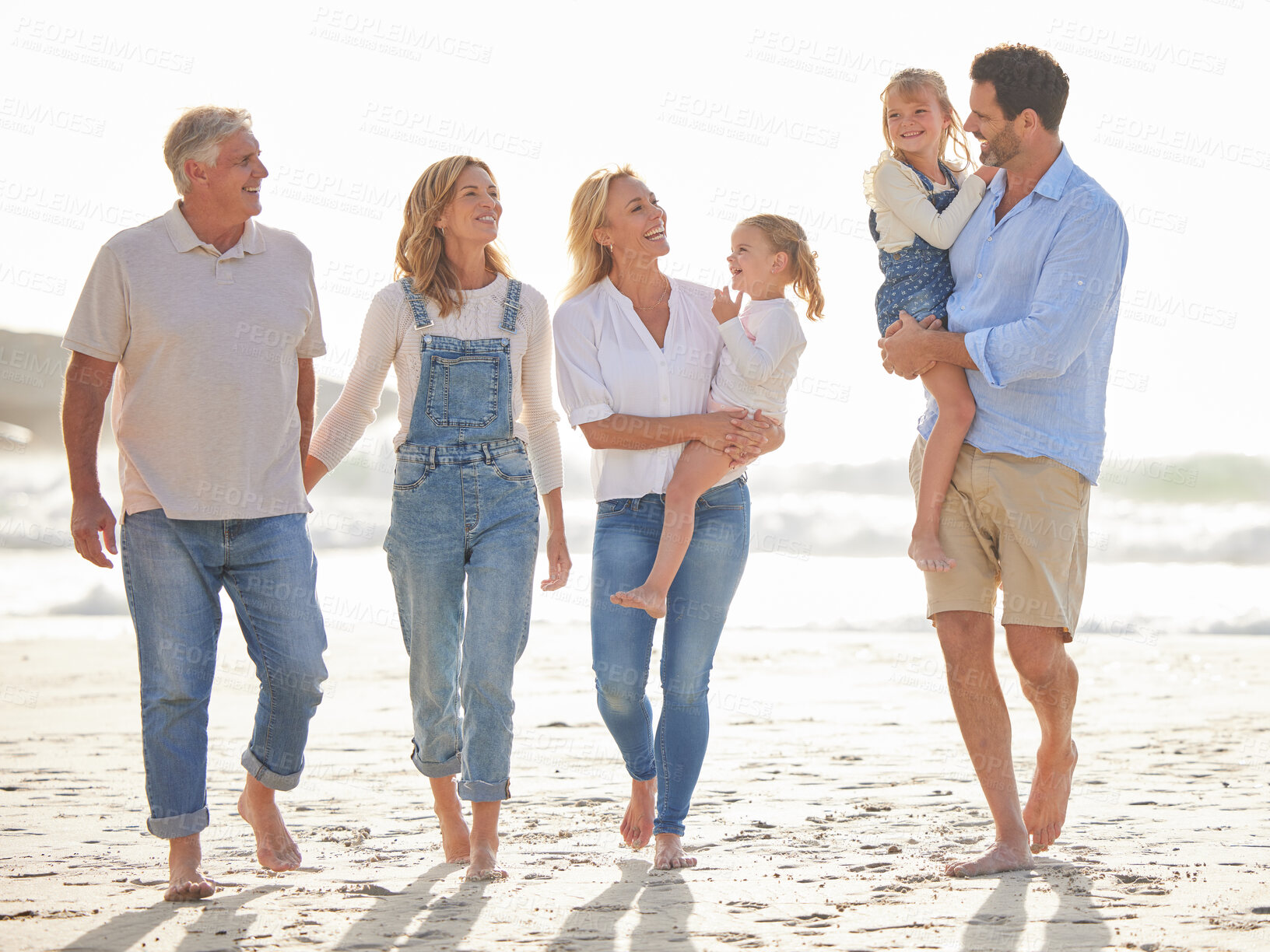 Buy stock photo Walking, family and happy on beach for adventure, connection and together by ocean or sea. Water, people or grandparents with children for love, freedom and travel for vacation in summer or Miami