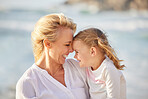 Closeup of a caucasian girl laughing while enjoying a day out with her mother at the beach. Mom and daughter enjoying a summer vacation by the sea. Enjoying family time while on holiday