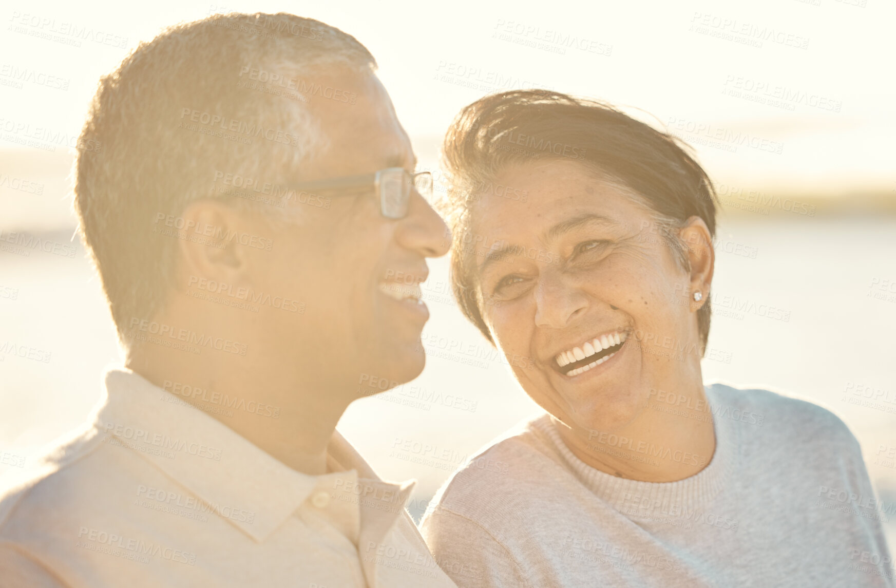 Buy stock photo Sunset, mature couple and relax at beach for date, holiday and summer vacation on island. Laugh, man and woman at ocean together for romantic getaway, travel and funny conversation outdoor for love