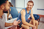 Cheerful friends talking in the gym. Happy players bonding and talking in a locker room. Men talking and relaxing before a match. Two athletes sitting and being social together