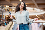 Portrait beautiful mixed race woman holding a credit card and standing in a mall shopping. Young hispanic woman carrying bags, spending money, looking for sales and getting in some good retail therapy