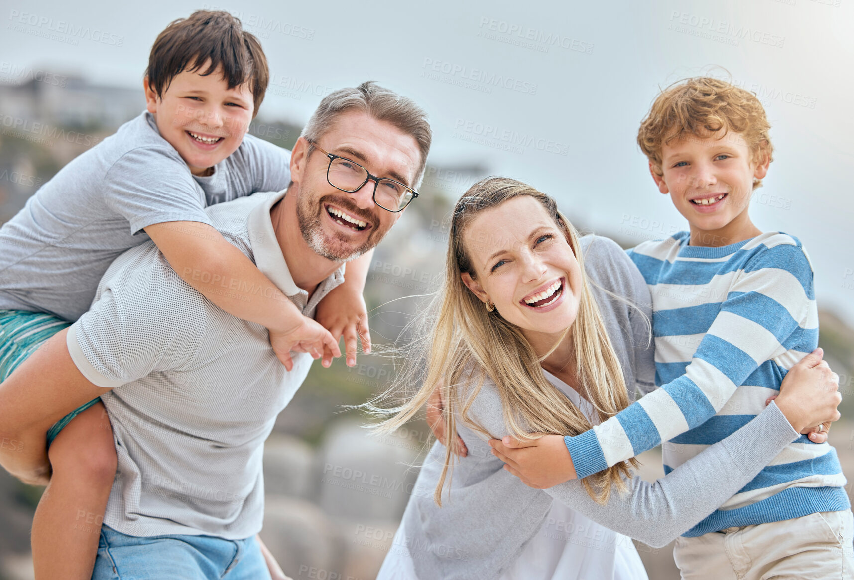 Buy stock photo Parents, children and smile at beach with portrait, hug and bonding with love on vacation in summer. Father, mother and kids on holiday for connection, embrace or together with piggy back in sunshine