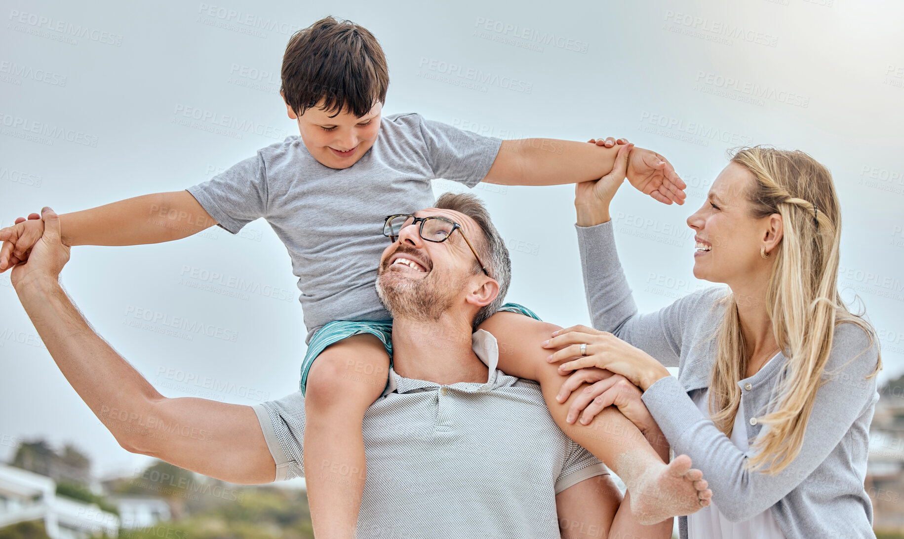 Buy stock photo Parents, children and shoulders at beach with plane, smile and bonding for love on vacation in summer. Father, mother and kids on holiday for airplane, excited and flight with piggy back in sunshine