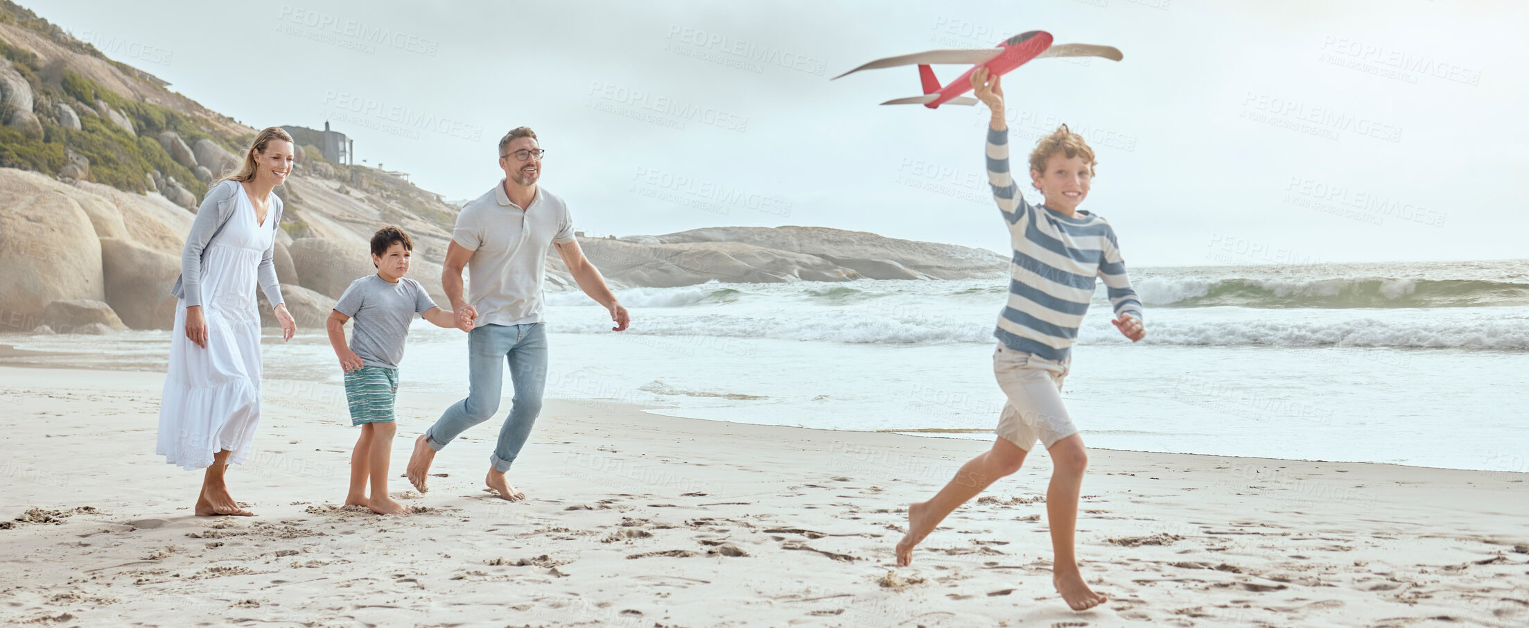 Buy stock photo Parents, children and plane toys at beach with running, smile or bonding with love on vacation in summer. Dad, mom and kids on holiday with airplane, games or playful with family in sunshine by ocean