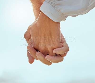 Buy stock photo Closeup, couple and holding hands with love outdoor for romance, affection and protection in relationship. People, trust and support with bonding, care and unity in marriage on honeymoon vacation