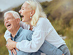 A happy mature caucasian couple enjoying fresh air on vacation at the beach. Smiling retired couple getting a cardio workout while being playful and having fun together on a romantic date