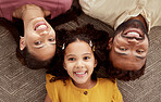 Above portrait of mixed race parents enjoying weekend with daughter in home living room. Smiling hispanic girl hugging mother and father and bonding in lounge. Happy couple lying together with child