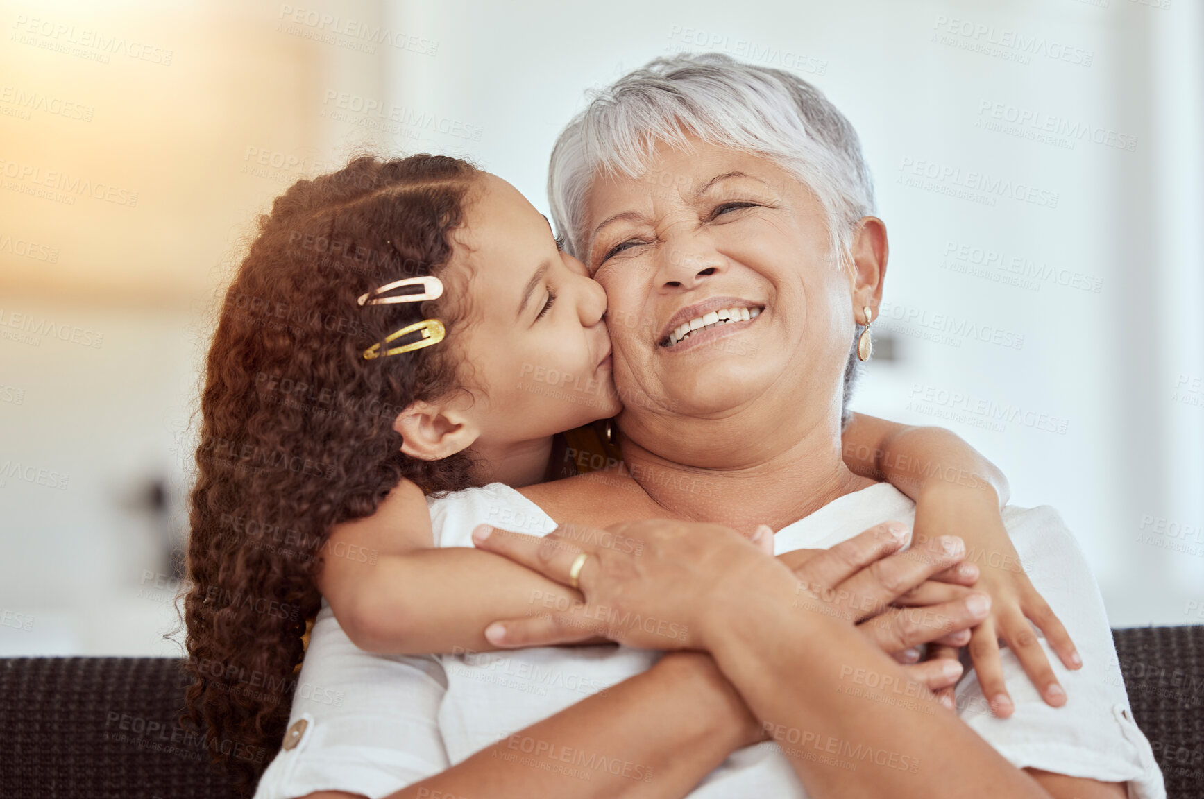 Buy stock photo Grandmother, girl and kiss for love in home, affection and bonding or care in apartment living room. Family, grandchild and grandma on couch and happy on weekend, comfort and smile in house lounge