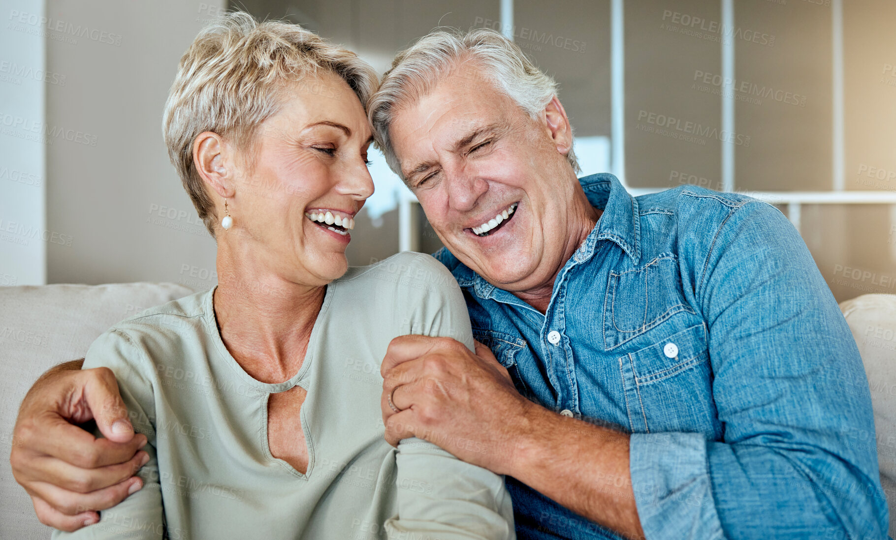 Buy stock photo Home, relax and old couple on couch, funny and happiness with love, romance and conversation. Apartment, senior man and mature woman with smile, marriage and relationship with joke in living room