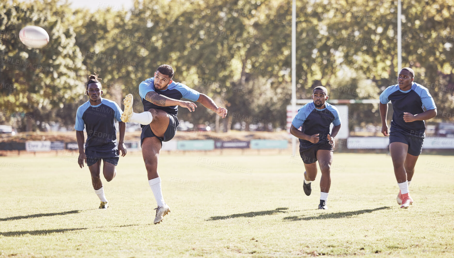 Buy stock photo Sports, kick and rugby team on field for training, match or skill development for try and defense. Fitness, outdoor and players with ball for scoring at practice, game or tournament at club stadium.