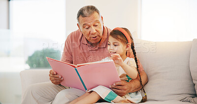 Buy stock photo Grandpa, child and reading book on sofa for literature, education or bonding together at home. Grandparent with little girl or kid smile for story, learning or relax on living room couch at house