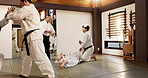 Students, aikido or learning Japanese martial arts in dojo for practice, body movement or self defense. Combat demonstration, group of people or training workout for fighting, education or class