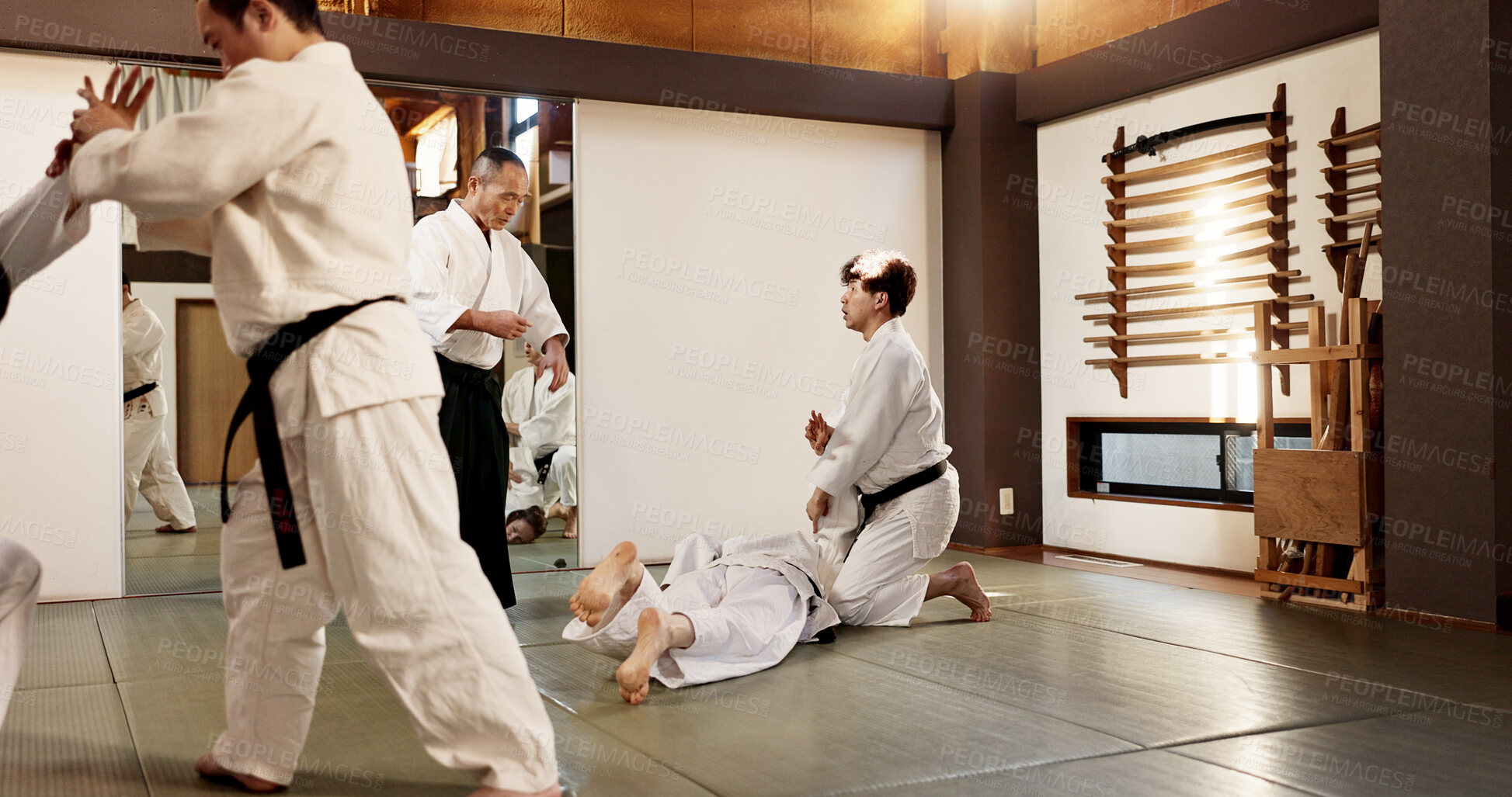 Buy stock photo Japanese master, student or training in martial arts in dojo place, block or fighting in aikido in self defence. Sensei, battle and guide in class with wisdom, combat and men in black belt discipline