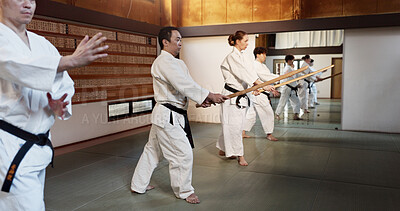 Buy stock photo Aikido, stick and fight class with weapon training and wooden sword for self defence exercise. Dojo, students and people in a gym or studio with workout, black belt practice and fitness in Japan