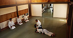Men in dojo with sensei for aikido training, fitness and development with action, exercise and coaching. Teaching, learning and students in traditional Japanese martial arts fight class with aikidoka