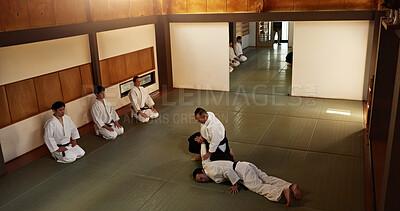 Buy stock photo Japanese master, student or teaching of martial arts in dojo place, block or fighting in aikido class in self defence. Sensei, battle and person on floor of skill, combat and discipline in respect