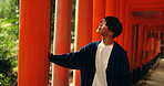 Thinking, walking and man in Torii gate in Kyoto with peace, mindfulness and travel with spiritual history. Architecture, Japanese culture and person in orange tunnel at Shinto shrine in zen mindset.