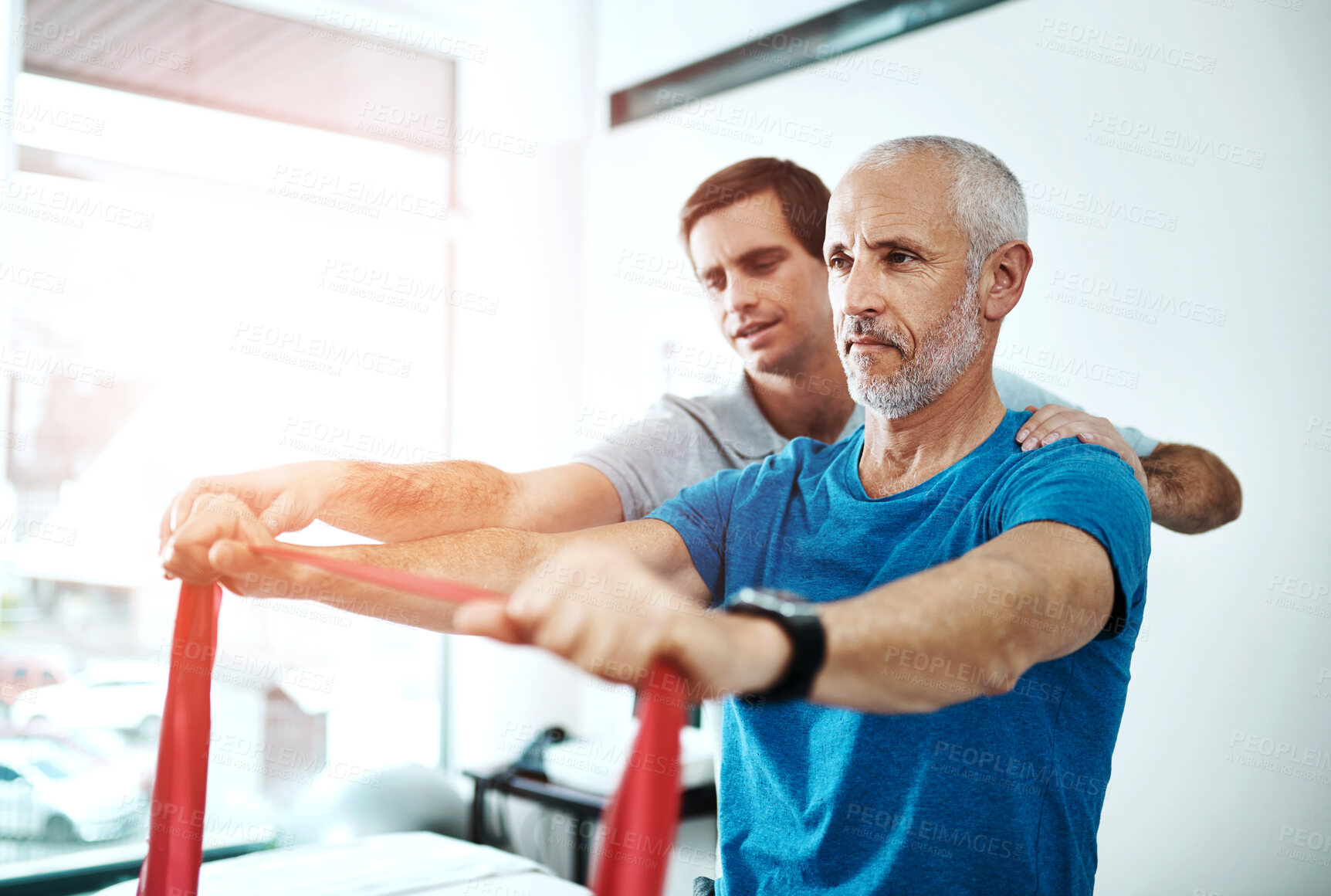 Buy stock photo Men, physiotherapy and mature patient with resistance band for stretching for rehabilitation and support on injury. People, healthcare and help for wellness or wellbeing at clinic for trust and care